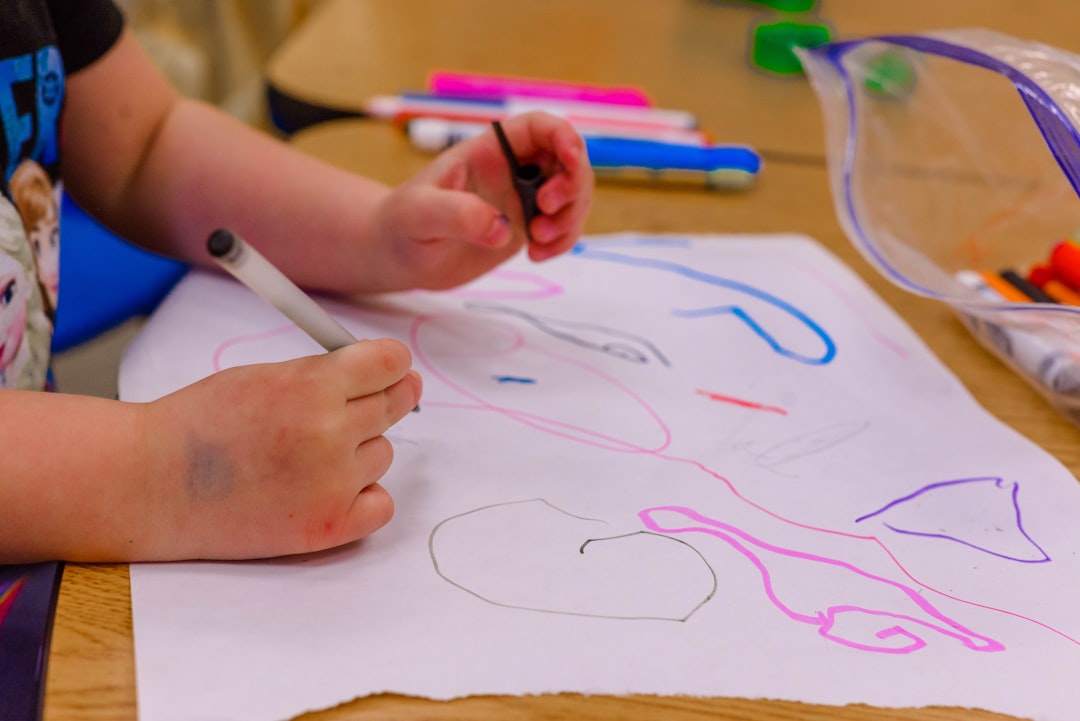 Children's hands drawing together with colourful felt-tip pens